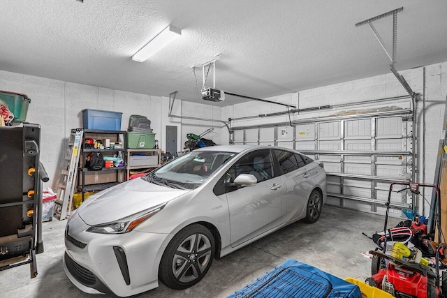 garage featuring concrete block wall and a garage door opener