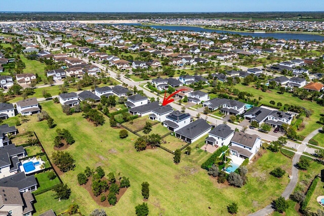 drone / aerial view featuring a residential view and a water view