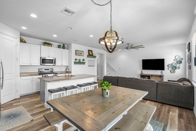 dining area featuring recessed lighting, wood finished floors, visible vents, and a textured ceiling