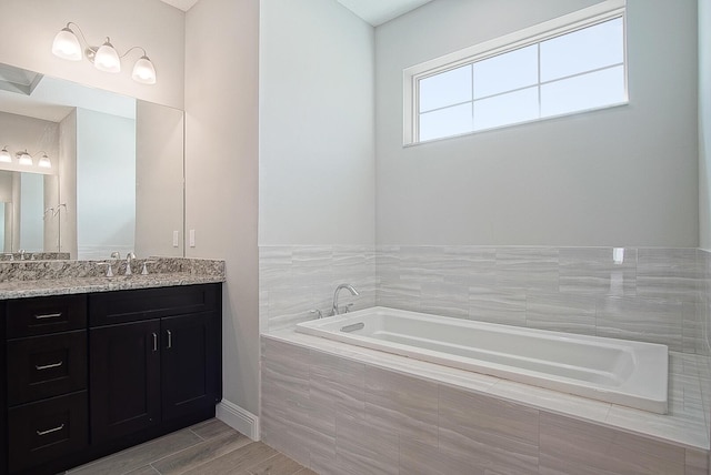 bathroom with vanity and a relaxing tiled tub