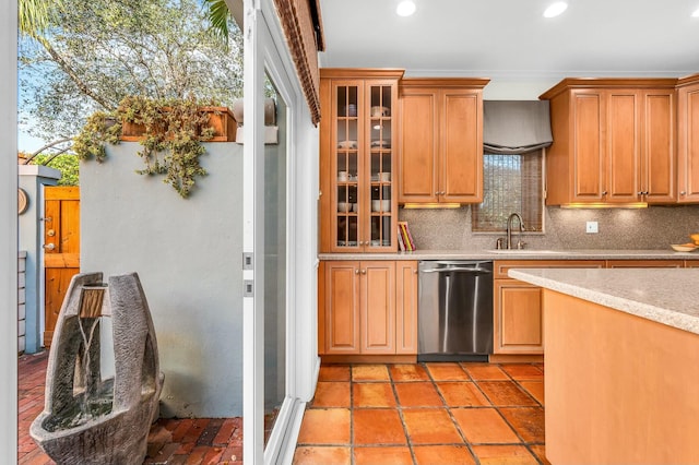 kitchen with stainless steel dishwasher, a sink, glass insert cabinets, and tasteful backsplash