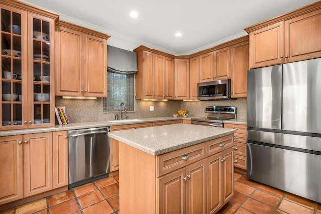 kitchen with a sink, a center island, appliances with stainless steel finishes, decorative backsplash, and glass insert cabinets