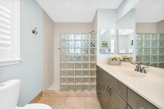 full bath featuring vanity, tile patterned flooring, walk in shower, and toilet