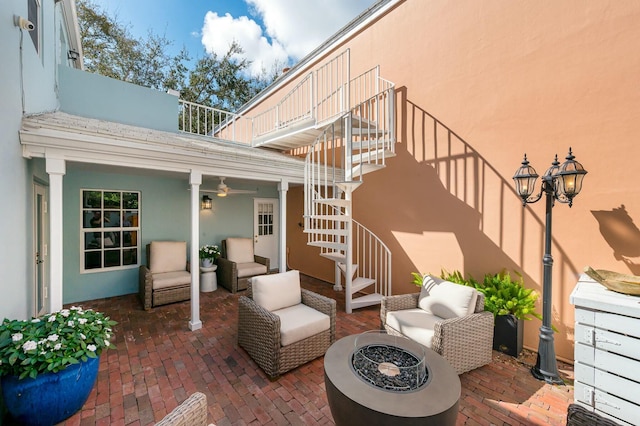 view of patio / terrace with stairway and an outdoor living space with a fire pit