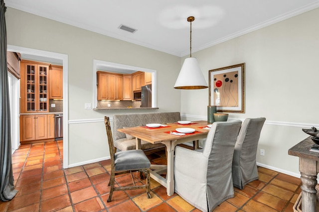 dining area featuring crown molding, light tile patterned flooring, visible vents, and baseboards