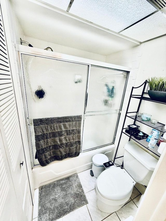 bathroom featuring shower / bath combination with glass door and toilet