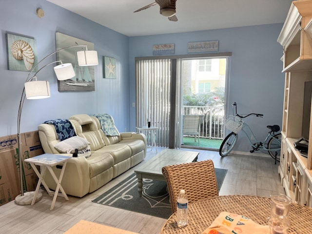 living room with ceiling fan and light hardwood / wood-style flooring