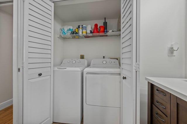 laundry area with separate washer and dryer and light wood-type flooring