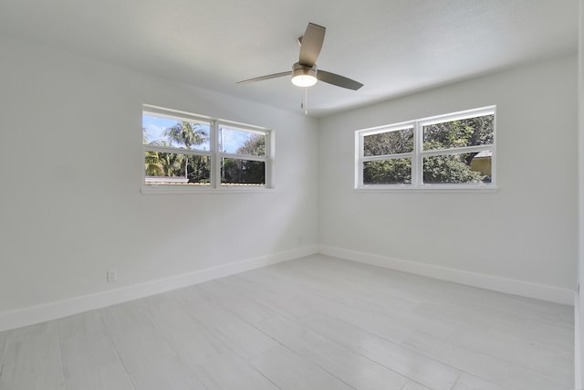 unfurnished room with a ceiling fan, a wealth of natural light, and baseboards