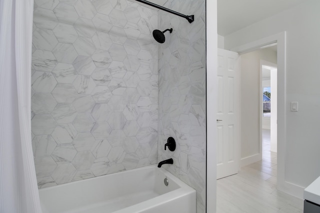 bathroom with shower / tub combo and baseboards