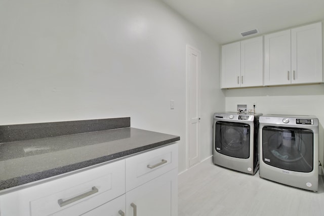 laundry room with cabinet space, visible vents, and washer and dryer