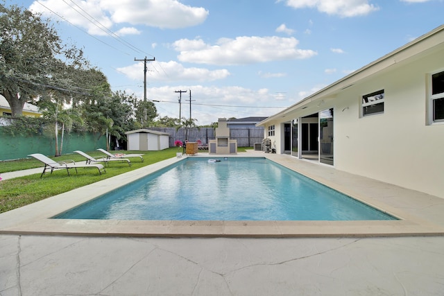 view of swimming pool with a storage shed, a lawn, a fenced in pool, a fenced backyard, and an outbuilding