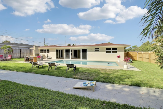 back of house featuring a yard, a patio, a fenced backyard, and stucco siding