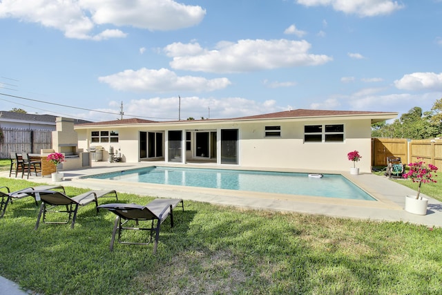 rear view of property with a fenced in pool, a yard, fence, and stucco siding