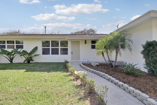 single story home featuring brick siding and a front lawn