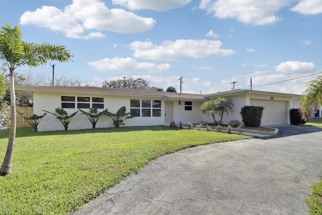 ranch-style home with a garage, brick siding, driveway, and a front yard