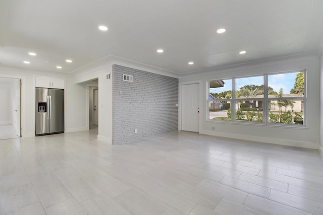 unfurnished room with recessed lighting, baseboards, visible vents, and brick wall