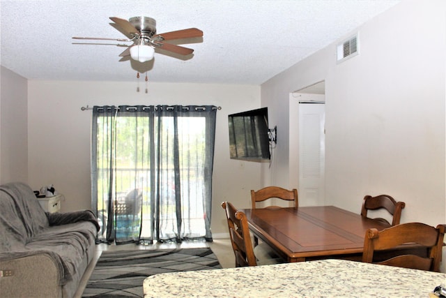 dining space with ceiling fan and a textured ceiling