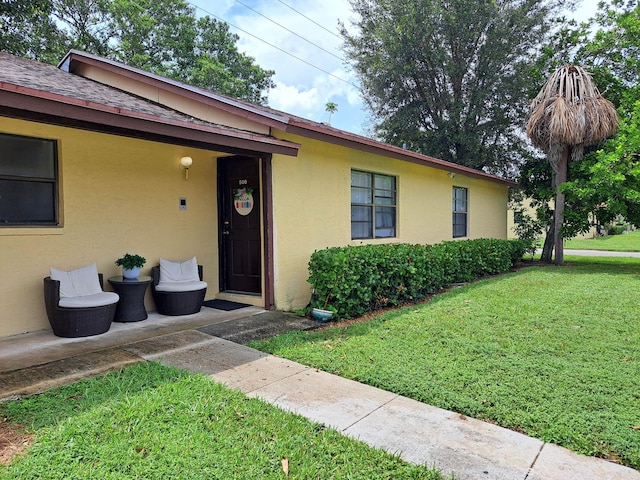 view of front facade with a front lawn and stucco siding