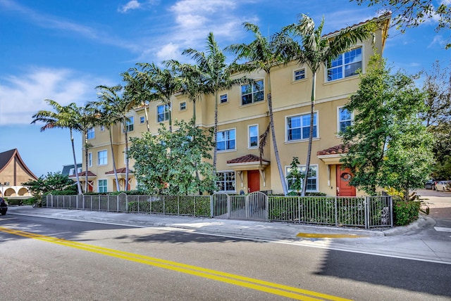220 S Federal Hwy Unit 4, Lake Worth Beach, FL 33460 - view of front of property with stucco siding, a fenced front yard, a tiled roof, and a gate