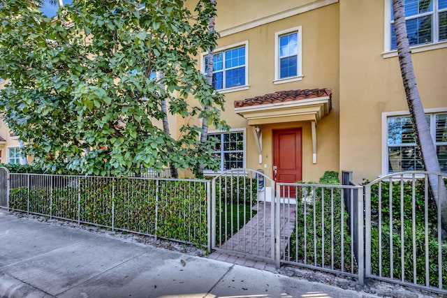 220 S Federal Hwy Unit 4, Lake Worth Beach, FL 33460 - view of front of property featuring stucco siding, a fenced front yard, and a gate