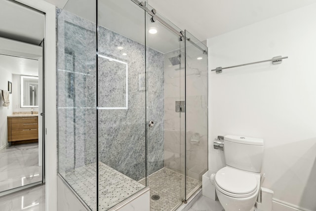 bathroom featuring toilet, a stall shower, baseboards, and vanity