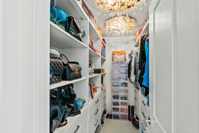 walk in closet with a notable chandelier