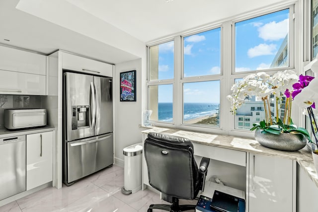 home office with marble finish floor, a water view, and a wealth of natural light