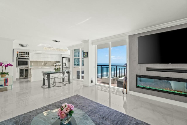 living area featuring ornamental molding, a glass covered fireplace, marble finish floor, and visible vents