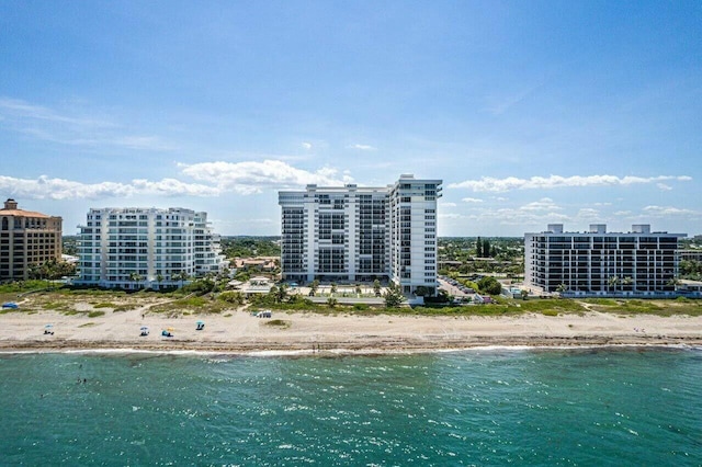 birds eye view of property featuring a water view, a view of city, and a beach view