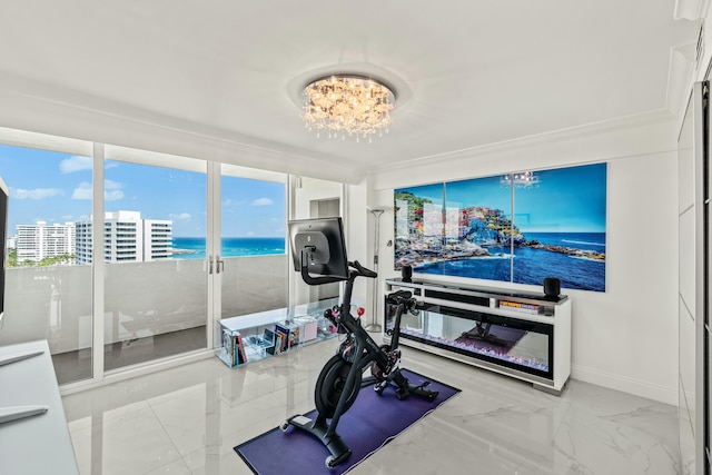 workout room featuring marble finish floor, a city view, baseboards, and an inviting chandelier