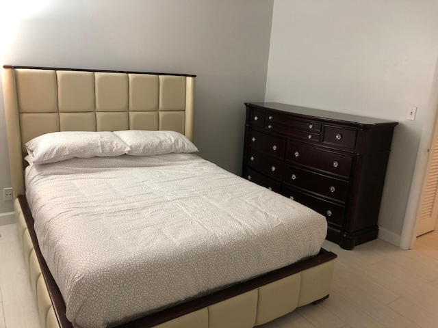 bedroom with light wood-style flooring and baseboards