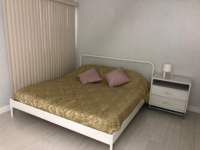 bedroom featuring dark wood-style flooring and baseboards