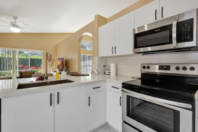 kitchen featuring sink, kitchen peninsula, appliances with stainless steel finishes, and white cabinets