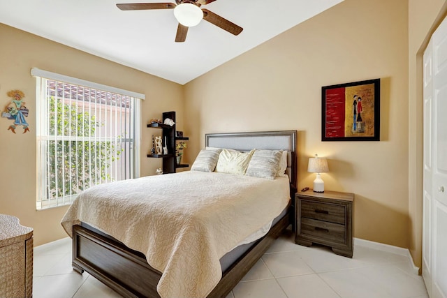 bedroom featuring ceiling fan, light tile patterned floors, and vaulted ceiling