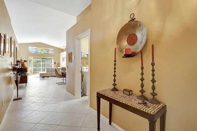 hallway featuring vaulted ceiling, washer / dryer, and light tile patterned floors