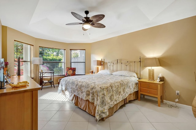tiled bedroom featuring a tray ceiling and multiple windows
