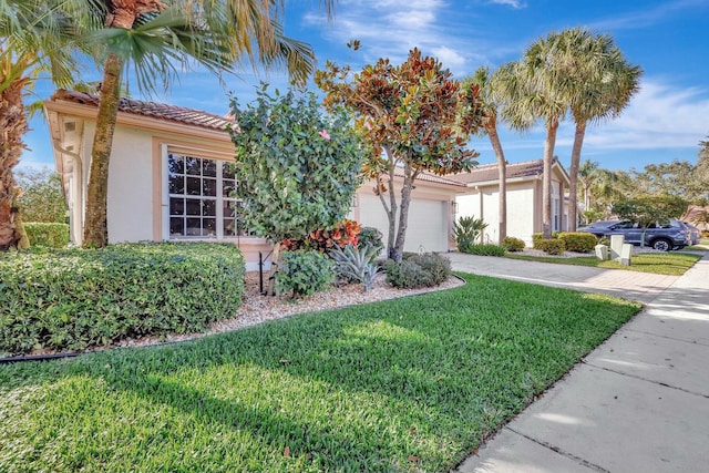 view of front of home with a garage and a front lawn