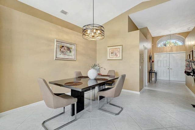 dining space featuring light tile patterned floors, a chandelier, and vaulted ceiling