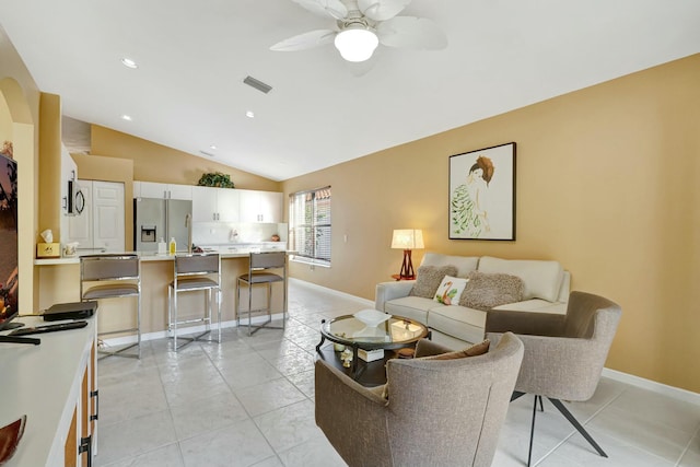 living room with vaulted ceiling, ceiling fan, and light tile patterned floors