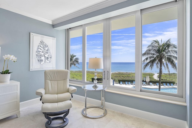 sitting room with a water view, baseboards, and ornamental molding