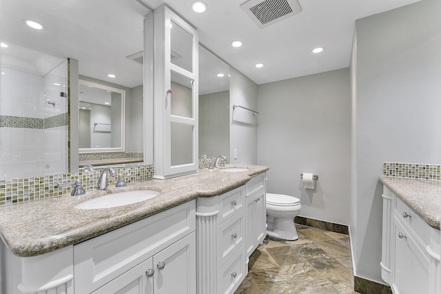 bathroom featuring toilet, tasteful backsplash, visible vents, and a sink