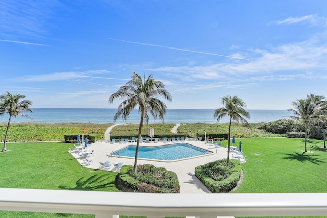 pool with a water view, a lawn, and a patio