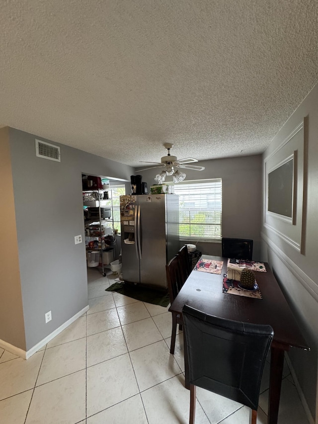 dining space featuring light tile patterned flooring, a textured ceiling, and ceiling fan