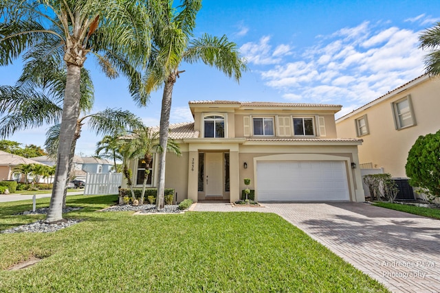 mediterranean / spanish-style home with a front yard, central AC, decorative driveway, and stucco siding