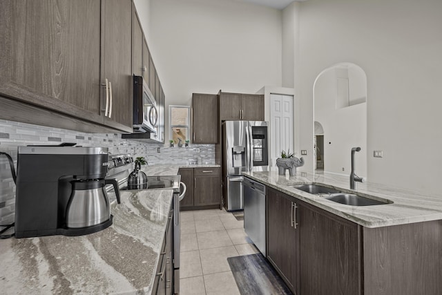 3036 Calle Valencia, West Palm Beach, FL 33409 - kitchen with light stone countertops, a kitchen island with sink, appliances with stainless steel finishes, and a sink