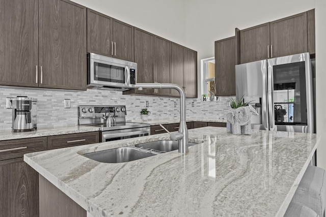 3036 Calle Valencia, West Palm Beach, FL 33409 - kitchen featuring light stone countertops, appliances with stainless steel finishes, and dark brown cabinets