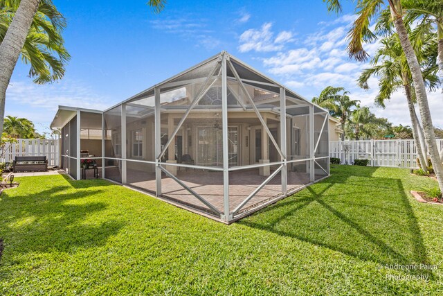 3036 Calle Valencia, West Palm Beach, FL 33409 - rear view of property with glass enclosure, a fenced backyard, a yard, and a patio