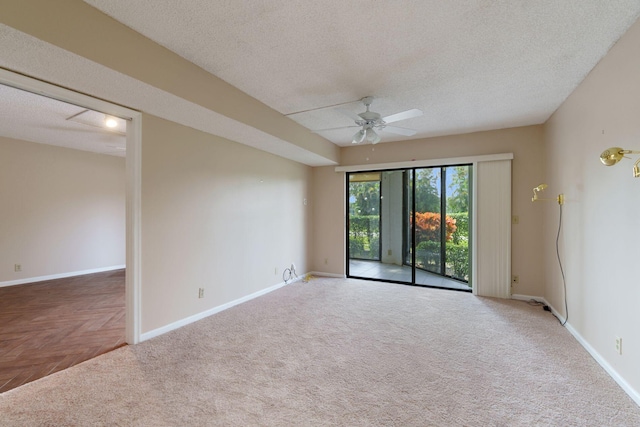 carpeted spare room with a ceiling fan, baseboards, and a textured ceiling