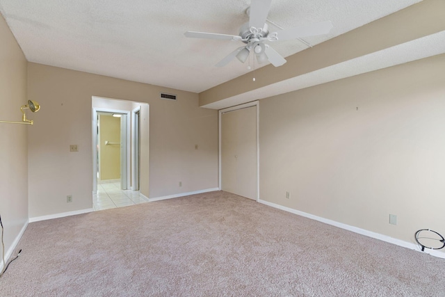 empty room with light carpet, baseboards, visible vents, and a textured ceiling